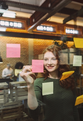 Woman writing on Post it note